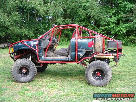 Off-road vehicle with red roll cage, large tires, and no doors