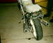 1986 Honda Interceptor - The rear section of a motorcycle is visible, showing its exhaust, chain, and damaged seat.