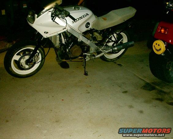 White Honda motorcycle, 3q-front view, with visible 'HONDA' text and 'VFR' badge