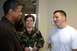 1996 Ford Probe - A man in a brown jacket talks with a woman in military camouflage and another man in a white t-shirt.