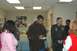 1996 Ford Probe - Denzel Washington is seen signing a document in an indoor setting, surrounded by several individuals.