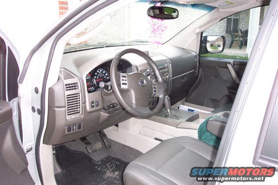 2004 Nissan Titan interior, gray seats, dashboard with gauges, steering wheel with Nissan logo