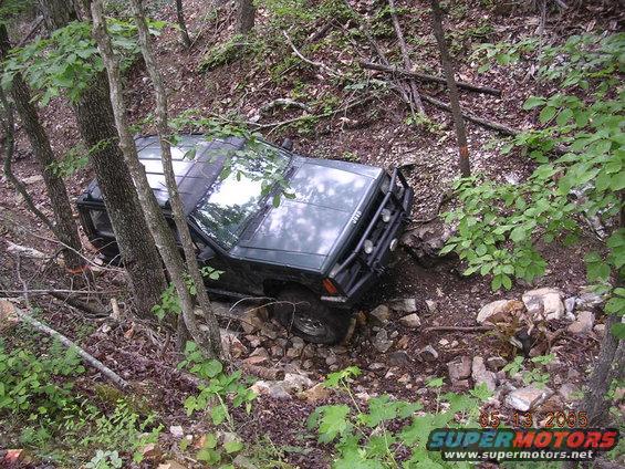 Dark green 1995 Jeep Cherokee on rocky trail, front bumper visible