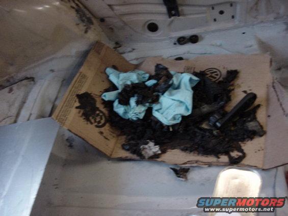 Interior view of vehicle with debris on cardboard, showing a Volkswagen logo