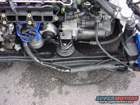Engine bay with blue spark plug wires and black hoses
