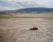 1996 Ford Probe - A red 1996 Ford Probe is parked in a barren, dusty landscape with tire tracks visible on the ground.