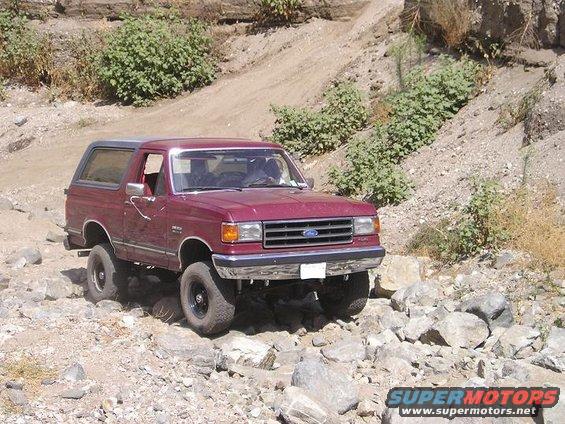 Maroon 1989 Ford Bronco navigating rocky terrain