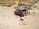 1989 Ford Bronco - A maroon Ford Bronco tackles a challenging off-road course with rocky terrain.