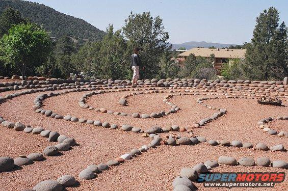 Person in stone labyrinth with Supermotors.net logo