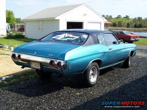 Teal 1971 Chevrolet Chevelle coupe with black vinyl top, parked next to a red car