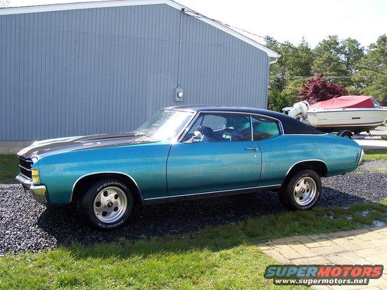 Teal 1971 Chevrolet Chevelle coupe with a black vinyl top parked next to a building