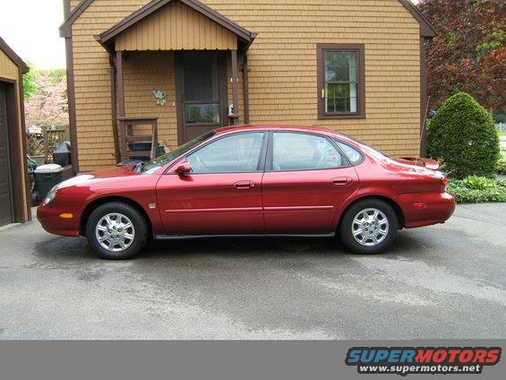1998 Ford Taurus sedan, side view, parked in front of a house