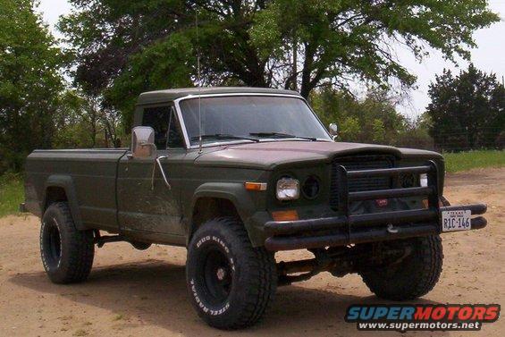 Olive green Jeep J-10 pickup truck with bull bar and off-road tires. Texas license plate RIC-146