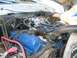 1979 Ford F-150 - The engine bay of a 1979 Ford F-150 shows a blue valve cover and a Holley carburetor.