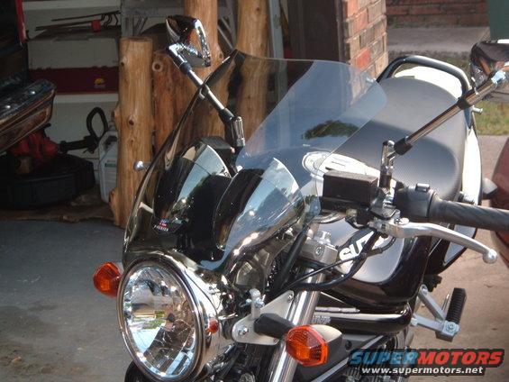 Black motorcycle front view with aftermarket fairing and Suzuki logo visible