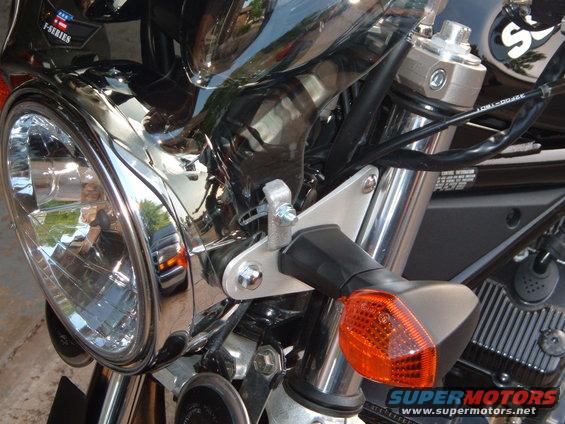 Close-up of a motorcycle's front headlight and orange turn signal assembly