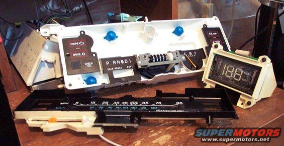 Disassembled car dashboard with gauges, odometer, and digital display showing 188