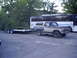 1979 Ford Bronco - 1979 Ford Bronco, two-tone brown and tan, towing a flatbed trailer.