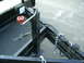 1979 Ford Bronco - Close-up view of a trailer's tongue mechanism, including a winch and safety chains.