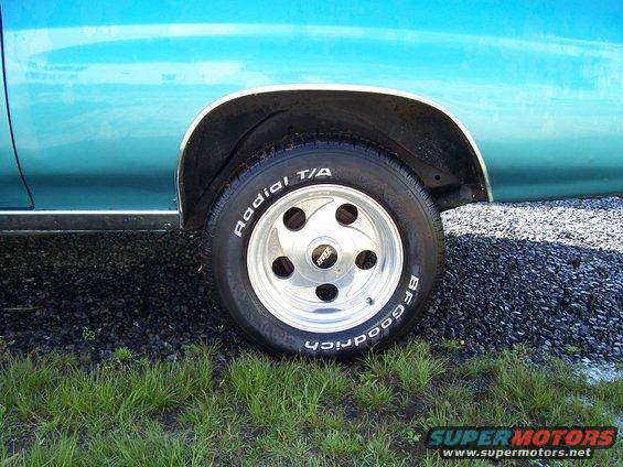 Close-up of a blue car's rear wheel with BFGoodrich Radial T/A tires and a five-spoke aftermarket rim