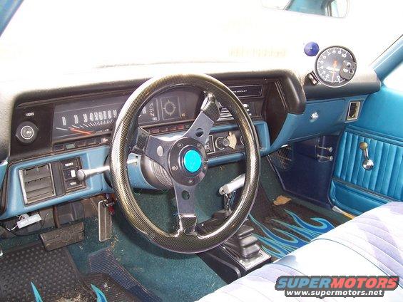 1971 Chevrolet Chevelle interior with blue seats, aftermarket steering wheel, and flame floor mats