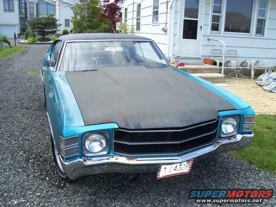 1971 Chevrolet Chevelle front view, blue body with matte black hood, parked on gravel driveway