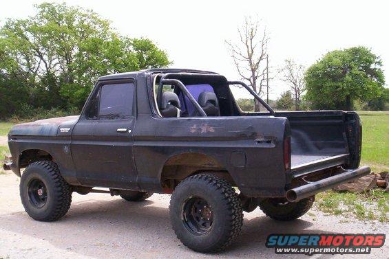 Black 1978 Ford Bronco, 3/4 front view, lifted with off-road tires, roll cage, open rear bed