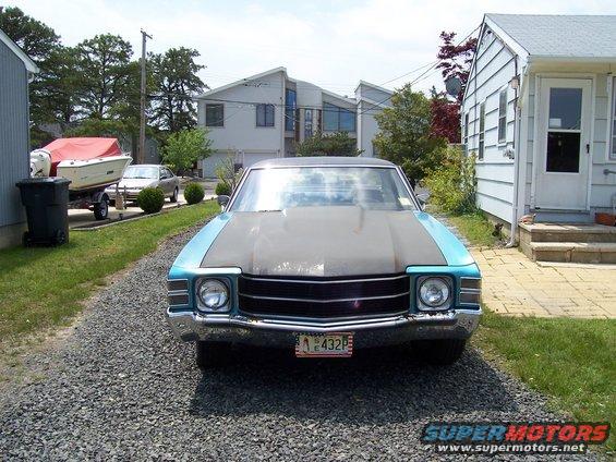 1971 Chevrolet Chevelle with a matte gray hood and teal fenders, parked in a driveway