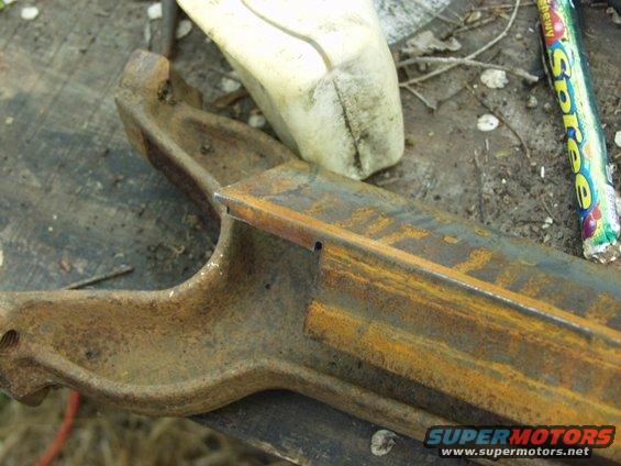close-up of rusty metal part with a piece of candy wrapper nearby