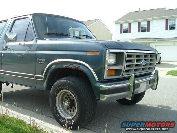 Green Ford Bronco, front quarter view. Shows rust on fender