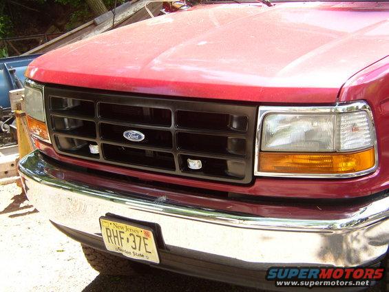 Red truck front grille with Ford logo and New Jersey license plate RHF 37E