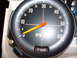 1978 Ford Mustang II - A close-up of a vehicle's tachometer gauge, showing engine RPM and a high beam indicator light.