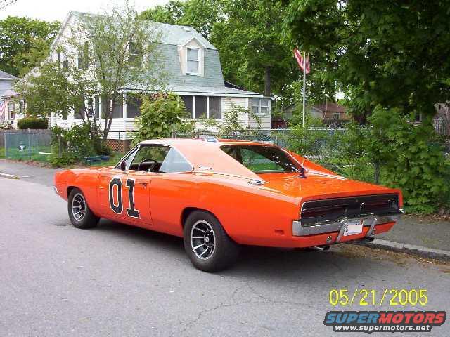 Orange 1969 Dodge Charger with "01" on doors, parked on street
