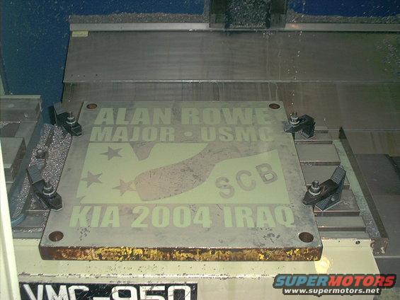 Memorial plaque with text 'ALAN ROWE MAJOR - USMC SCB KIA 2004 IRAQ' clamped to a VMC-950 milling machine