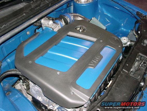 Engine bay with blue paint and black engine cover with VR6 text. Supermotors.net logo visible