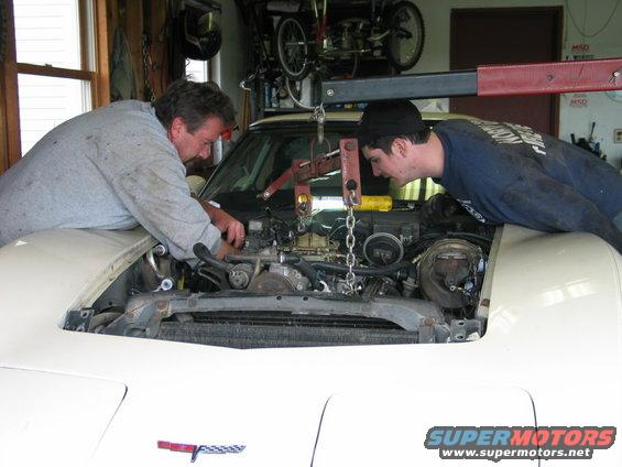 White 1981 Chevrolet Corvette engine bay with two mechanics working