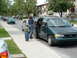 1979 Ford Bronco - Minivan parked on street with people getting in, other vehicles visible.