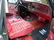 1979 Ford Bronco - The interior of this Ford Bronco shows a red dashboard and seats, with a "Built Ford Tough" floor mat visible.