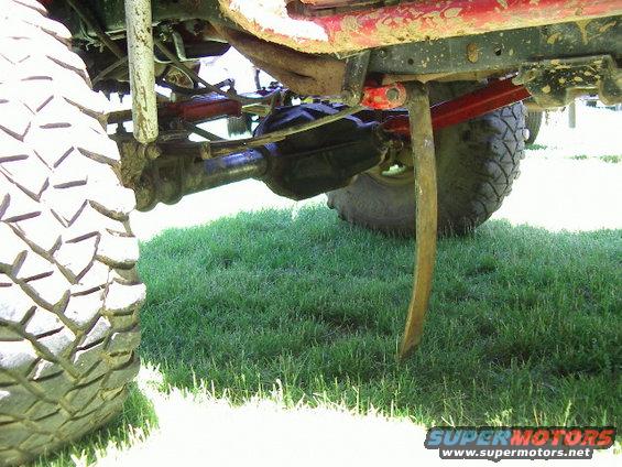 Off-road vehicle's large tire, suspension components, and differential visible