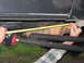 1989 Ford Bronco - Measuring a suspension part with a tape measure, likely for a lift kit installation.