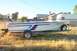 1982 Ford F-250 - A white boat with blue and red racing stripes is parked on a trailer in a grassy yard.