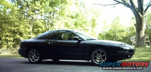 Black 1995 Ford Probe coupe parked on asphalt, side view with front quarter angle
