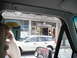 1979 Ford Bronco - A white station wagon is seen driving past storefronts, one of which is labeled 'Dogs Breath Bar'.