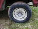 1979 Ford Bronco - Close-up of a 1979 Ford Bronco's wheel and tire, a white rim and a chrome hubcap with the Ford logo.