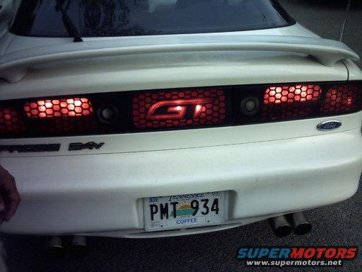 White car rear with honeycomb taillights, spoiler, and Tennessee license plate PMT 934