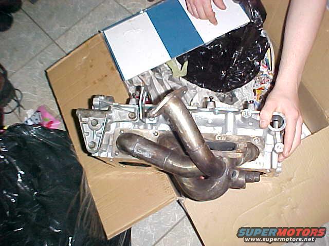 Engine exhaust manifold part in a cardboard box