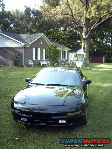 black 1995 Ford Probe parked on grass in front of a house