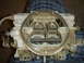 1986 Ford Mustang - A close-up view of a carburetor, a critical engine component, is shown against a plaid background.