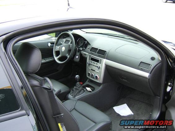 Car interior shot showing dashboard, steering wheel, seats, and center console
