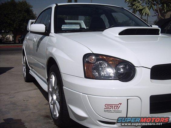 White Subaru Impreza WRX STI, front quarter view. Has STI badge on bumper